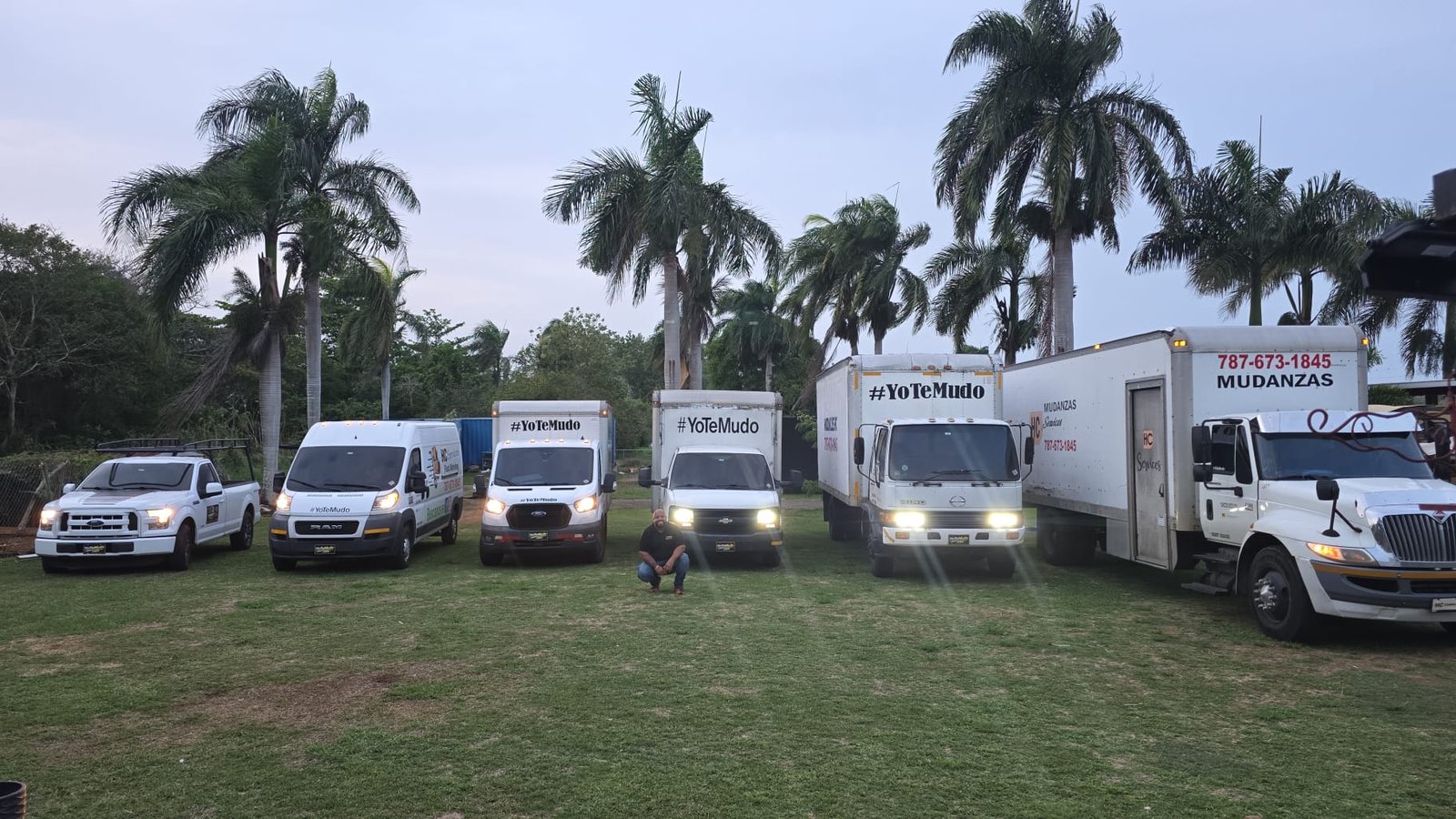 Flota de HC Services alineada: camionetas, vans y camiones de mudanza rotulados con YoTeMudo